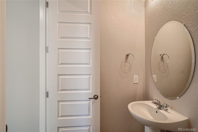 bathroom featuring a sink and a textured wall