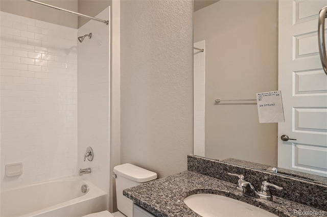 full bathroom featuring vanity, bathing tub / shower combination, toilet, and a textured wall