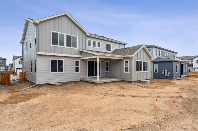 back of property featuring board and batten siding and roof with shingles