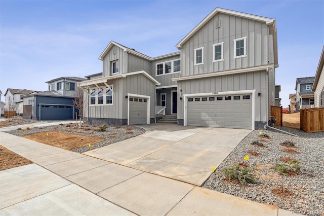 view of front of property featuring board and batten siding, driveway, a garage, and fence