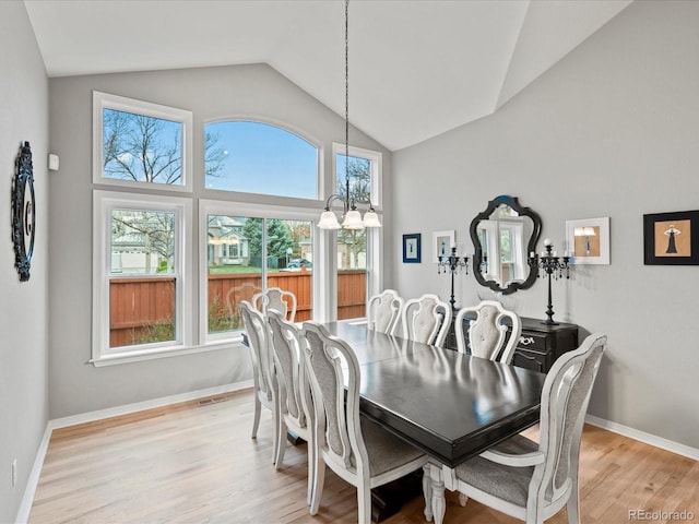 5497 W Prentice Ct, Littleton, CO 80123 - dining area featuring lofted ceiling, plenty of natural light, a chandelier, and light wood-type flooring