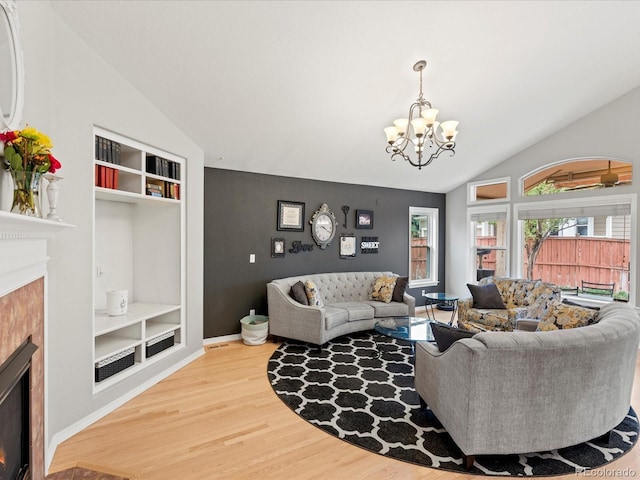5497 W Prentice Ct, Littleton, CO 80123 - living room featuring a warm lit fireplace, lofted ceiling, built in features, wood finished floors, and a chandelier