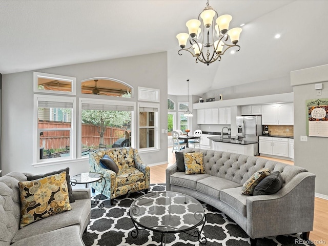 5497 W Prentice Ct, Littleton, CO 80123 - living room with a chandelier, light wood-style floors, and high vaulted ceiling