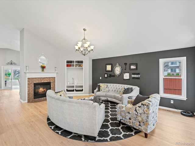 5497 W Prentice Ct, Littleton, CO 80123 - living room with a chandelier, light wood finished floors, a tiled fireplace, built in features, and lofted ceiling