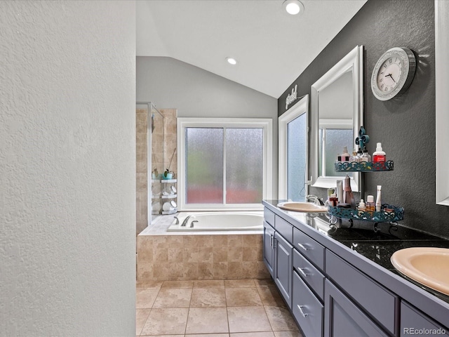5497 W Prentice Ct, Littleton, CO 80123 - bathroom featuring a textured wall, a bath, double vanity, lofted ceiling, and recessed lighting