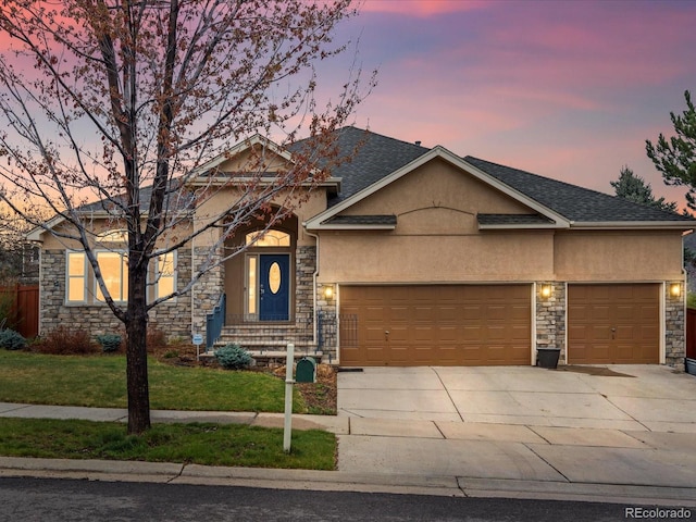 5497 W Prentice Ct, Littleton, CO 80123 - view of front of home featuring stone siding, stucco siding, a garage, driveway, and a lawn