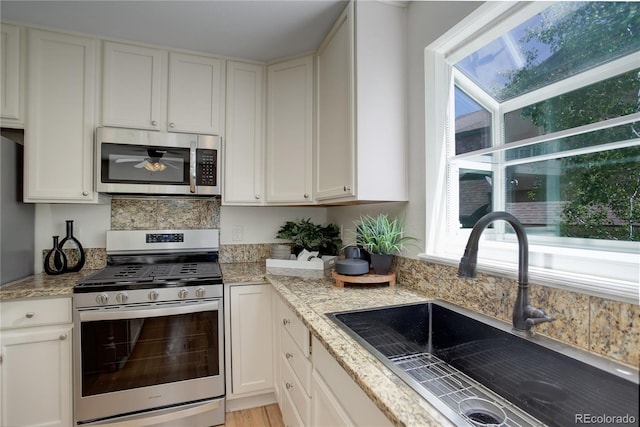 2840 Canyon Crest Ln, Highlands Ranch, CO 80126 - kitchen featuring appliances with stainless steel finishes, a sink, and white cabinets