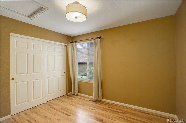 2840 Canyon Crest Ln, Highlands Ranch, CO 80126 - unfurnished bedroom with light wood-style flooring, baseboards, a closet, and attic access