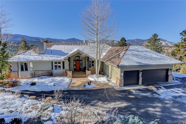 ranch-style house featuring a garage and a mountain view