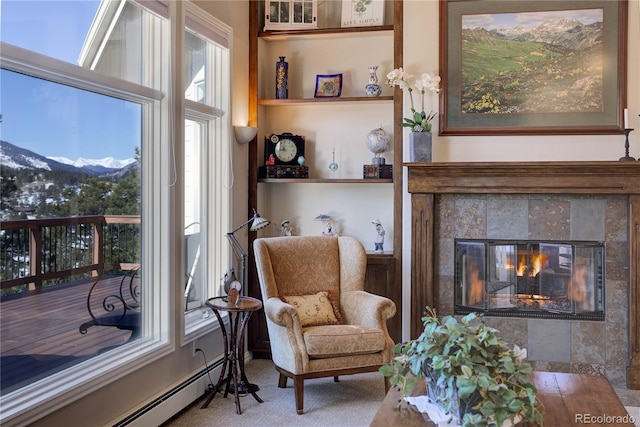 living area featuring baseboard heating, a mountain view, and a tile fireplace