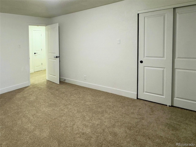 unfurnished bedroom with light colored carpet and a closet