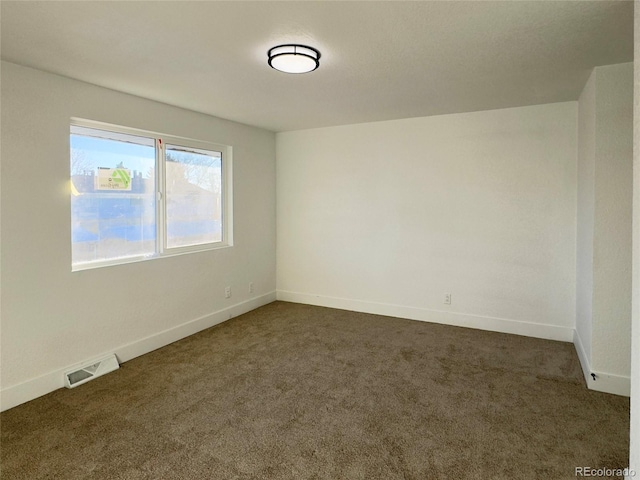 unfurnished room featuring dark colored carpet