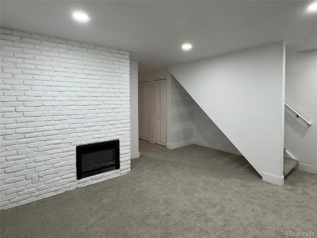 basement with a large fireplace and light colored carpet