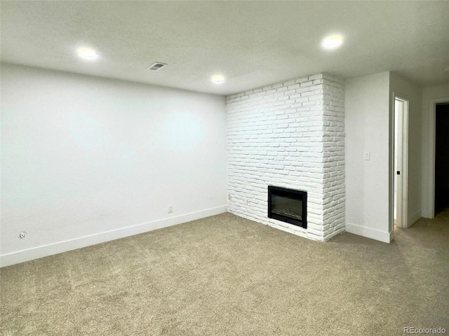 unfurnished living room with a brick fireplace and light colored carpet