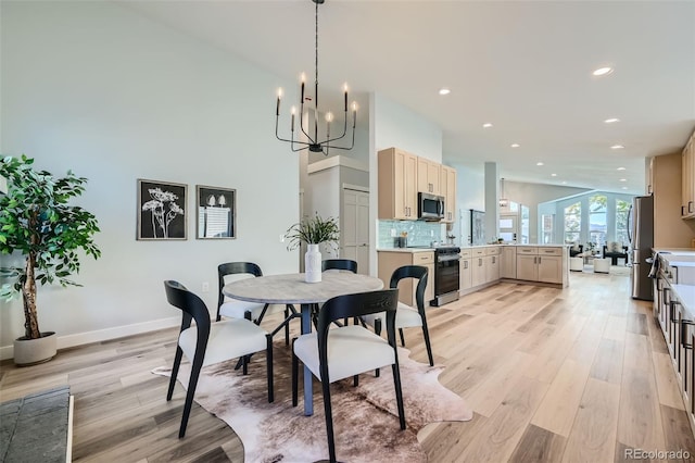 dining space featuring light hardwood / wood-style flooring and a chandelier