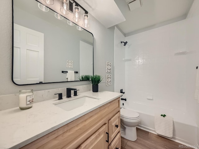 full bathroom featuring wood-type flooring, shower / bathtub combination, vanity, and toilet