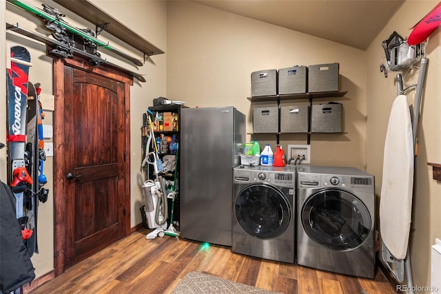 washroom with laundry area, wood finished floors, and washer and clothes dryer