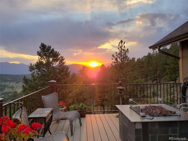 wooden deck with a fire pit and a mountain view
