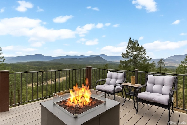 wooden deck with a fire pit and a mountain view