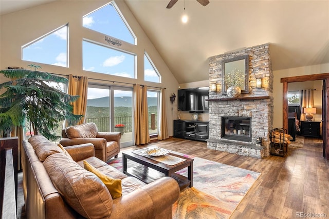 living room featuring a ceiling fan, high vaulted ceiling, hardwood / wood-style floors, and a fireplace