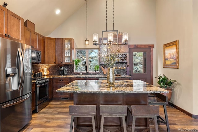 854 Dick Mountain Dr, Bailey, CO 80421 - kitchen with appliances with stainless steel finishes, high vaulted ceiling, a breakfast bar, stone countertops, and glass insert cabinets