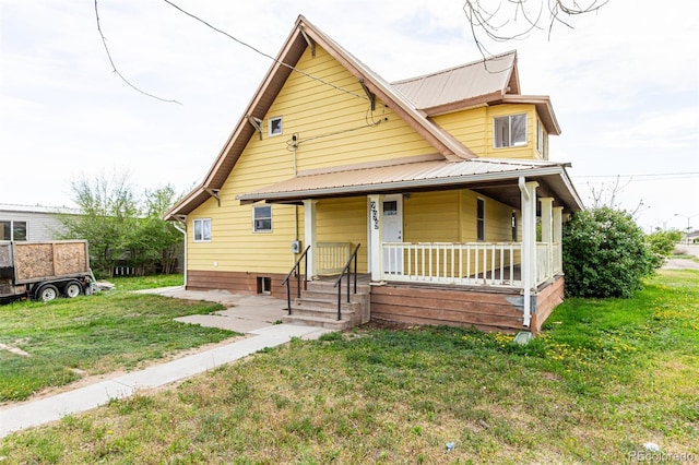 299 4th Ave, Limon, CO 80828 - view of front of property with covered porch, a front yard, and metal roof