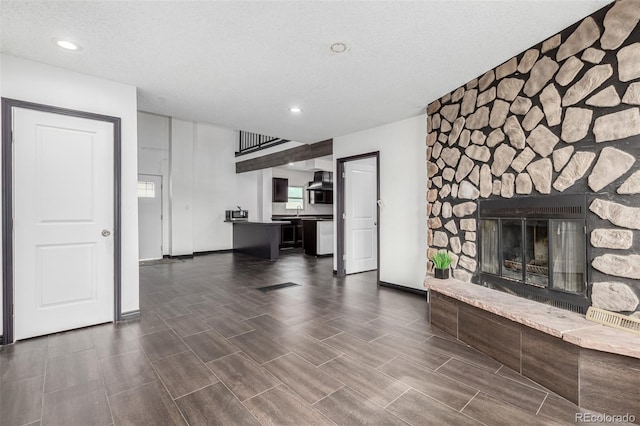 299 4th Ave, Limon, CO 80828 - unfurnished living room featuring a fireplace, recessed lighting, baseboards, and a textured ceiling