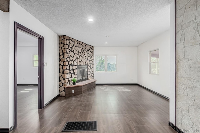 299 4th Ave, Limon, CO 80828 - unfurnished living room with a textured ceiling, wood finished floors, a fireplace, recessed lighting, and baseboards