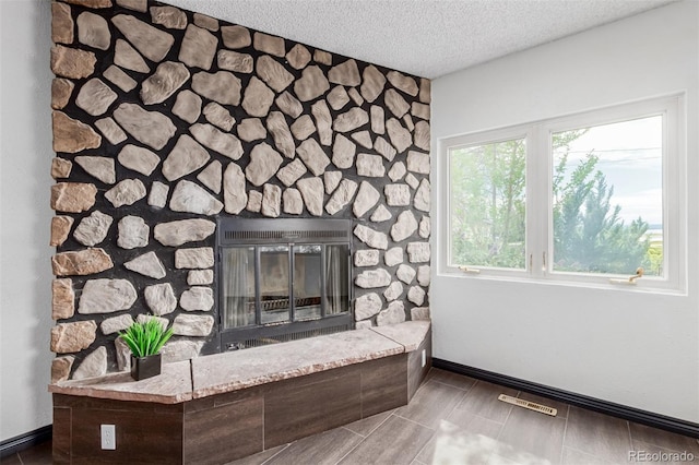 299 4th Ave, Limon, CO 80828 - detailed view of a textured ceiling, a stone fireplace, and baseboards
