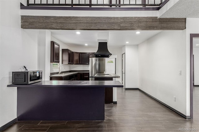 299 4th Ave, Limon, CO 80828 - kitchen featuring dark brown cabinetry, a peninsula, baseboards, dark wood-type flooring, and recessed lighting