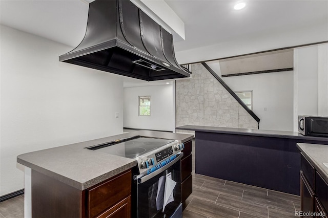 299 4th Ave, Limon, CO 80828 - kitchen featuring stainless steel electric range oven, ventilation hood, tasteful backsplash, wood tiled floors, and dark brown cabinets