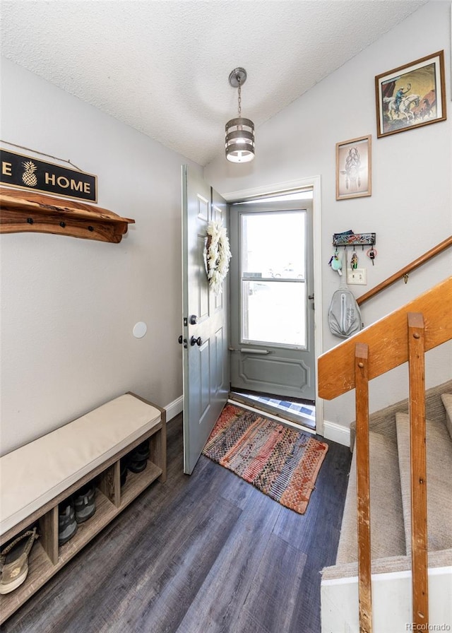 interior space featuring baseboards, dark wood-style floors, and a textured ceiling