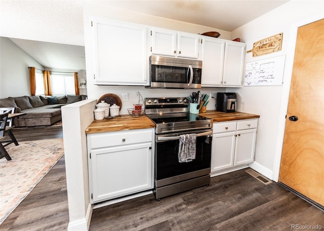 kitchen featuring white cabinets, stainless steel appliances, dark wood finished floors, and butcher block countertops