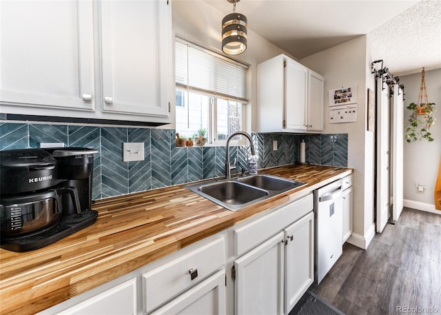 kitchen with white cabinets, a sink, wooden counters, backsplash, and stainless steel dishwasher