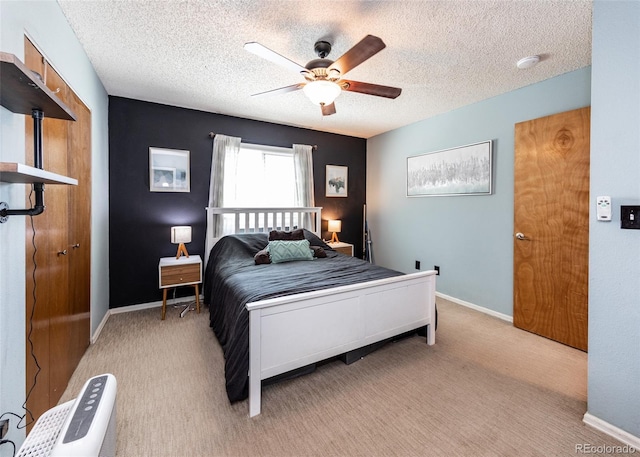 carpeted bedroom featuring baseboards, a ceiling fan, and a textured ceiling