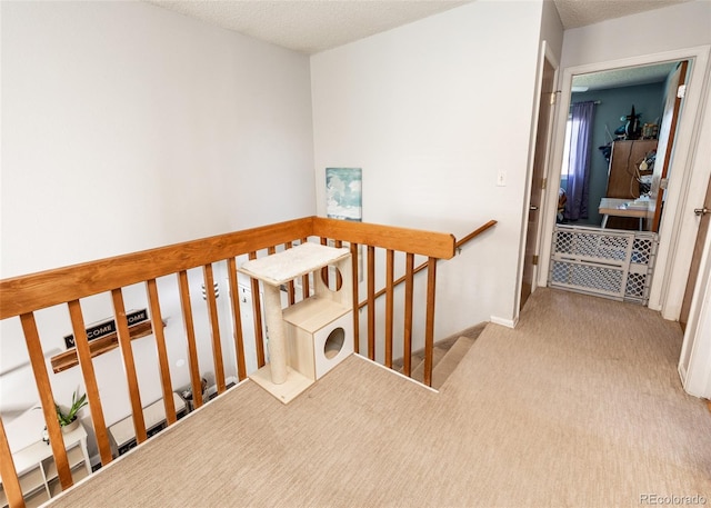 stairs featuring carpet and a textured ceiling