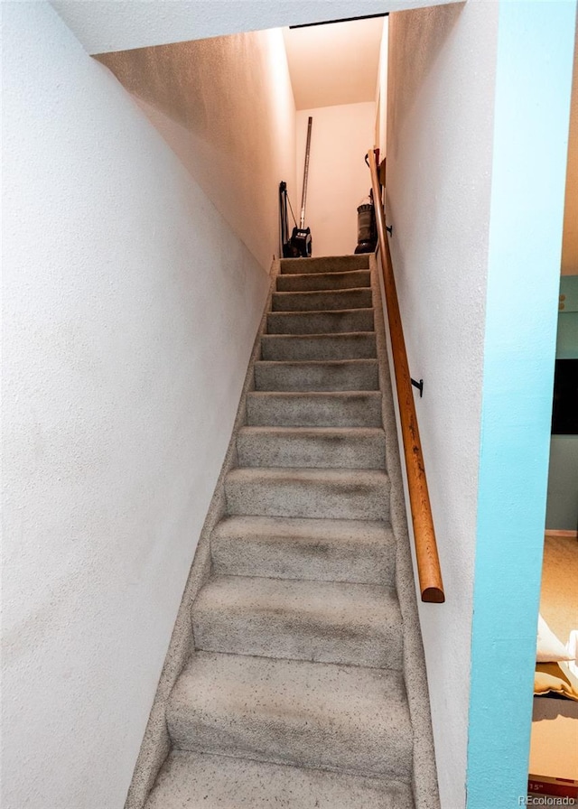 stairs featuring a textured wall