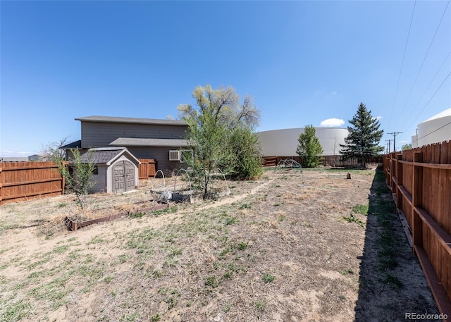 view of yard with a storage shed, an outdoor structure, and a fenced backyard