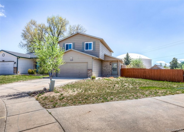 traditional-style home with brick siding, an attached garage, fence, and driveway
