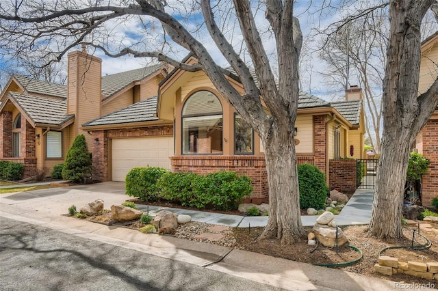 4565 E Mexico Ave Unit 3, Denver, CO 80222 - view of front of house featuring a chimney, brick siding, an attached garage, and concrete driveway