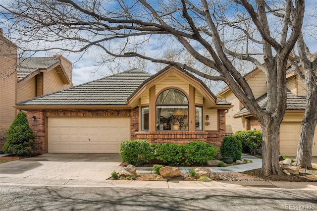 4565 E Mexico Ave Unit 3, Denver, CO 80222 - view of front facade with an attached garage, brick siding, concrete driveway, and a tile roof