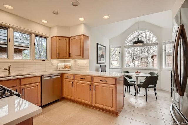 4565 E Mexico Ave Unit 3, Denver, CO 80222 - kitchen with appliances with stainless steel finishes, a peninsula, light countertops, vaulted ceiling, and tasteful backsplash