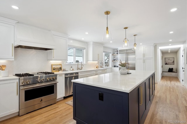 kitchen with white cabinets, premium range hood, and high end appliances