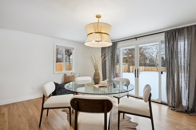 dining area featuring light wood-style flooring, baseboards, and french doors