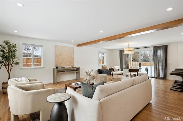 living room featuring baseboards, light wood-style flooring, beam ceiling, and recessed lighting