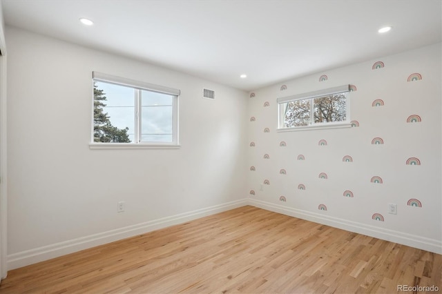 spare room featuring recessed lighting, light wood-type flooring, visible vents, and baseboards