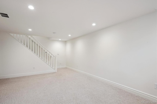 interior space featuring recessed lighting, light carpet, visible vents, baseboards, and stairway