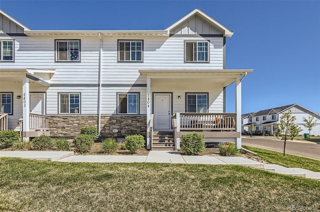 4355 24th Street Rd Unit 2804, Greeley, CO 80634 - townhome / multi-family property with a porch, board and batten siding, a front lawn, and stone siding