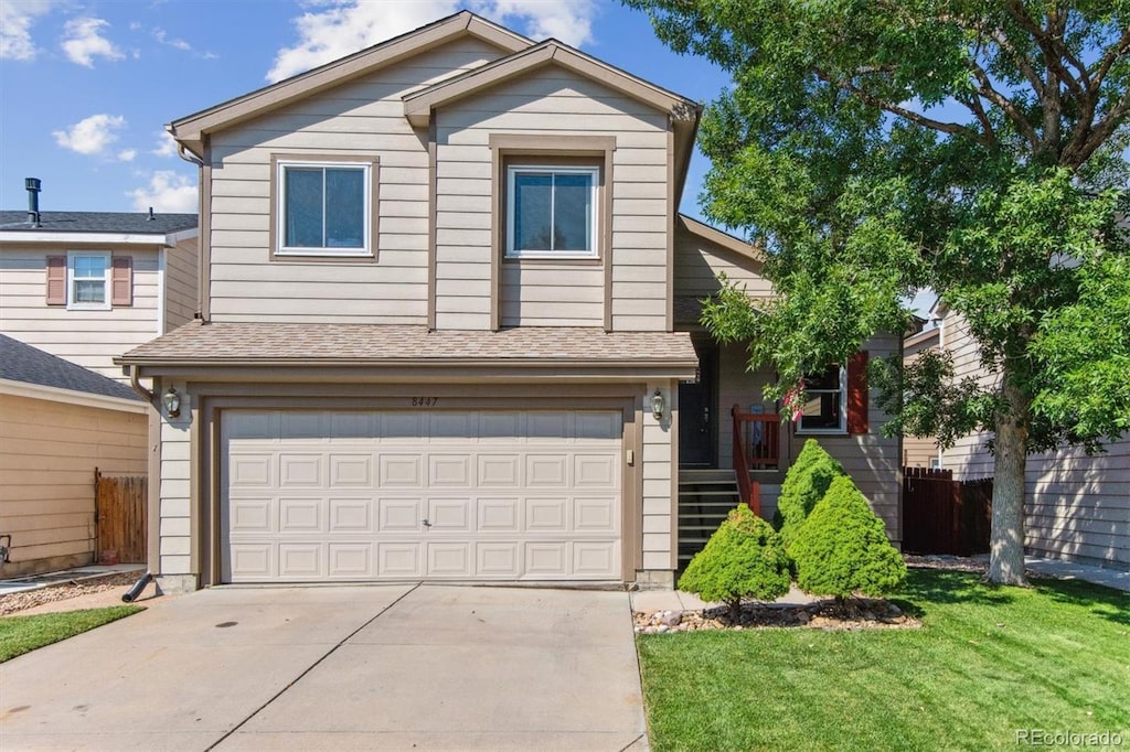 front facade with a garage and a front yard