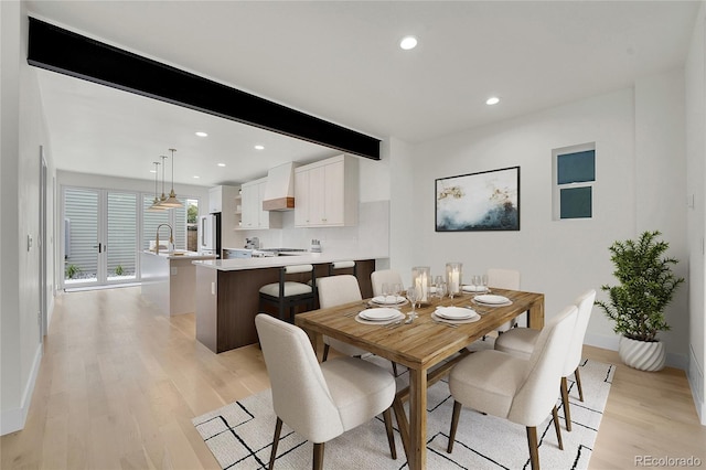 dining area with recessed lighting, beam ceiling, light wood-style flooring, and baseboards